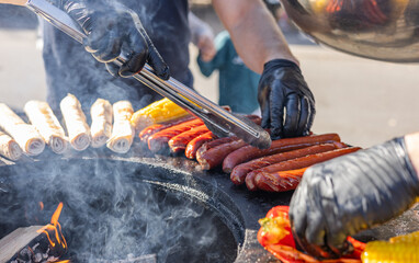 Delicious grilled steak meat with vegetables on barbecue grill with smoke and flames. Popular outdoor summer activity for friends and family. Fried pita bread on the grill.