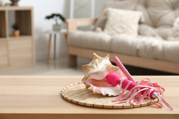 Wall Mural - Seashell with vibrator and whip on table in living room, closeup