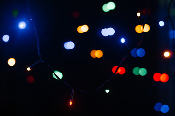 Colorful christmas lights bokeh on dark blue background.