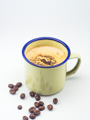 Homemade moccacino topped with choco granule served in an enamel mug, garnished with coffee beans on a white background