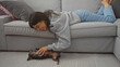 © Krakenimages.com - A smiling young woman enjoys a playful moment with her pet chihuahua inside a cozy living room.