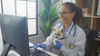 © Krakenimages.com - A smiling hispanic woman veterinarian holding a chihuahua dog inside a veterinary clinic.