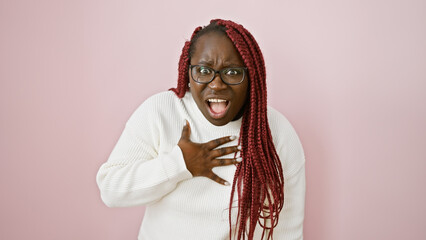 Wall Mural - Surprised african american woman with braids wearing glasses over pink background