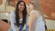 © Krakenimages.com - Two women chatting and laughing together on a city street, showcasing friendship and urban lifestyle.