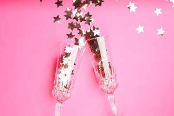 Poster - Wine glasses with confetti on pink background, flat lay. Christmas decor