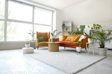 Canvas Print - Interior of light living room with green houseplants, sofa and armchair