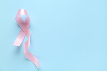 Wall Mural - Pink ribbon on blue background. World Cancer Day