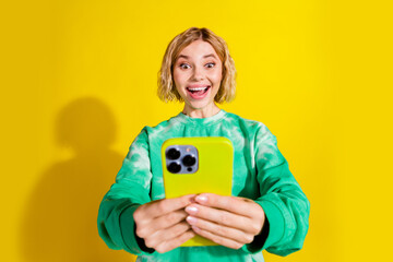 Wall Mural - Photo of charming positive woman wear green sweatshirt getting sms modern device empty space isolated yellow color background