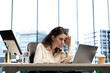 © DC Studio - Stressed overwhelmed business leader working in discomfort with a headache, feeling overburdened and uncomfortable at the office. Female executive deals with anxiety and fatigue.