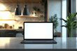 © Vitalii - Close-up of a laptop with white blank mock up screen on a marble table with a modern home kitchen in the background