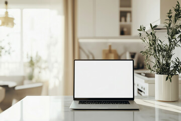 Close-up of a laptop with white blank mock up screen on a marble table with a modern home kitchen in the background