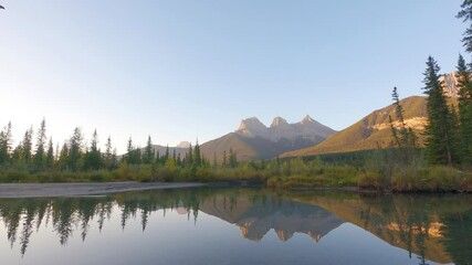 Wall Mural - 4k timelapse of beautiful reflection of three sister mountains on the water with a clear blue sky ba