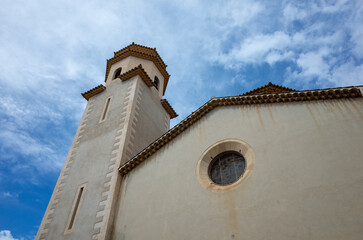 A tall white building with a steeple and a window