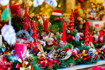 Decorated shopping stands with Christmas candles, fir trees and pine cones at outdoor Xmas fair