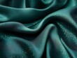 © Katarina - A close-up view of an elegant, green silk fabric adorned with shimmering golden specks, creating a luxurious and mesmerizing visual experience in soft folds.
