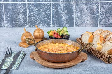 Famous Turkish name menemen in traditional copper pan. Menemen made with egg, pepper and tomato. Traditional Turkish dish Menemen concept for the menu.