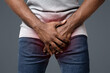 © Prostock-studio - Cropped of afro man holding his groin over white background. Men's health, impotence in young age