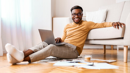 Aufkleber - Freelance Job. Happy Afro Man Working On Laptop Looking Aside Sitting On Floor At Home. Selective Focus