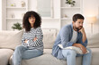 © New Africa - Couple having quarrel on sofa at home. Relationship problems