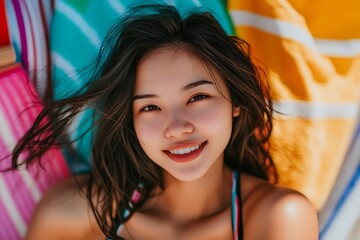 Close-up portrait of a young woman smiling, with her hair blowing in the wind.