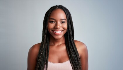 A joyful Black woman with long braided hair, wearing a sleeveless top, smiling brightly, wit