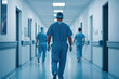 © Rutchaneewan - View of a doctor or nurse in protective gear walking through a hospital corridor, highlighting healthcare protocols and medical professionalism in clinical settings.