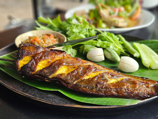 Grilled catfish Thai style serving with chili paste sauce and fresh vegetable