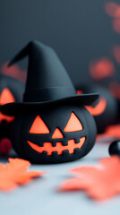 Sticker - A black pumpkin with a witch's hat sits on a table with orange leaves.