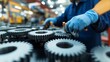 © sorrakrit - A skilled technician inspects gears in a manufacturing facility, showcasing precision and attention to detail in mechanical engineering.