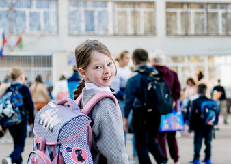 A schoolgirl with a large schoolbag goes to class.