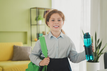 Wall Mural - Photo of charming pretty cheerful adorable girl learner wearing uniform back to school 1st september daylight indoors