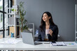 © apichat - A woman in a business suit is sitting at a desk with a laptop