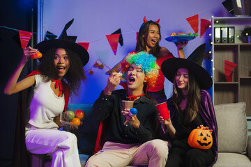 Wall Mural - Dinner and group of people celebrating together at Halloween party. Friends are happy and celebrating with food, wine and friendship of love and cheers of champagne at the event.