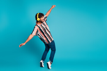 Poster - Full length photo of funky cool guy dressed striped shirt earphones dancing emtpy space isolated blue color background