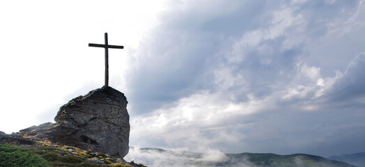 Wooden cross on a mountain against the sky. Biblical scene, concept of Holy Scriptures of Old and New Testaments, Christian religion