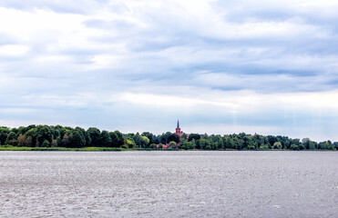 
a red castle can be seen over the lake among a forest of trees