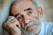 © Andrii - An elderly man resting his chin on his hand displaying deep emotions in a weathered environment