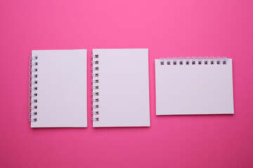 Wall Mural - Group of white blank spiral notebooks on pink background