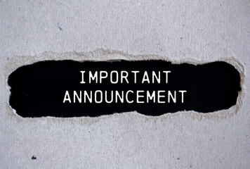 Important announcement message written on ripped torn gray paper with black background. Conceptual important announcement symbol. Copy space.