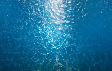 Poster - A deep blue body of water with light reflecting off the surface, creating a mesmerizing pattern of ripples and waves.