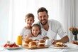 © Fotograf - A father and two young children sit together at a table sharing a meal
