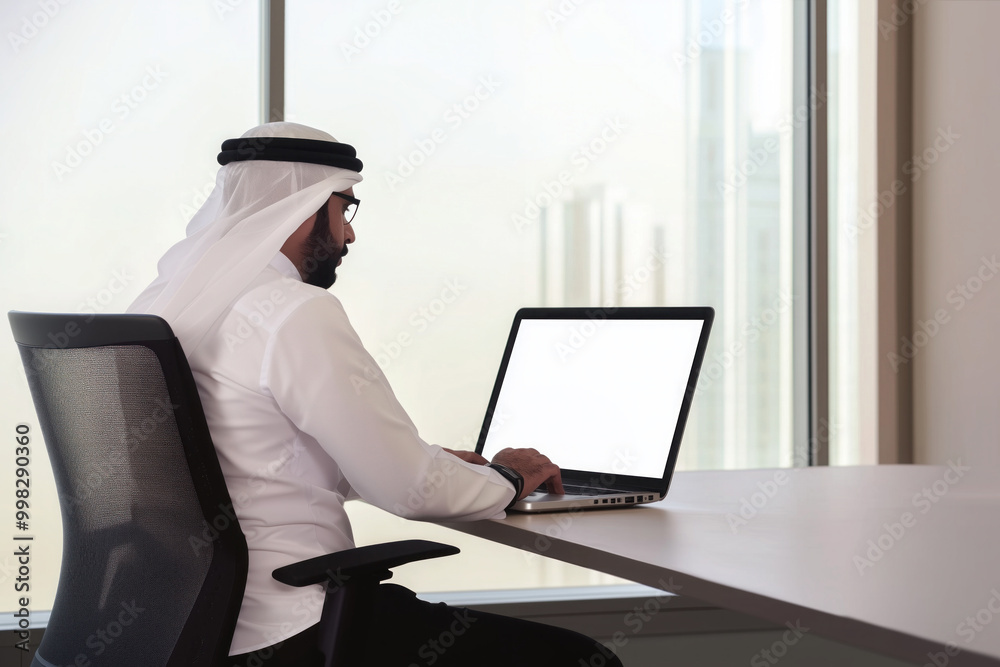 Young arab businessman or employee in traditional outfit working at a ...