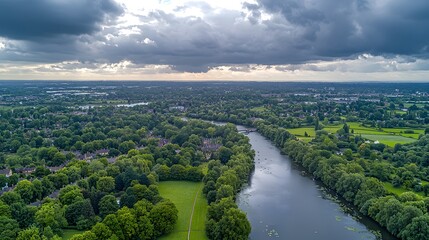 Aerial view of lush green landscape with a winding river under a stormy sky.