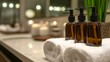 © pentolo - Three brown bottles with pumps, two white towels, and candles on a bathroom counter.