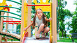 © Mariia - happy preschooler girl playing on a slide on the playground in summer
