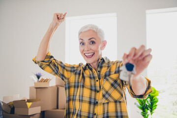 Poster - Portrait of pretty aged lady show key raise fist wear plaid shirt relocate move new flat indoors