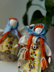 two traditional ukrainian motanka dolls with light blue headscarves and two long red braids each, st