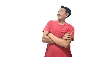 Portrait of amazed young Asian man crossed arms and looking aside at blank space isolated on white background