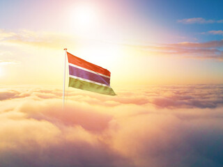 The Gambia national flag aerial view clouds in beautiful sky. Top view. Drone. Aerial bird's eye fly flag. Aerial top flag view cloudscape.  Flag with Sunrise or sunset over clouds.