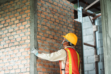 Construction worker  inspects the building construction standards to ensure that every part of the structure complies.